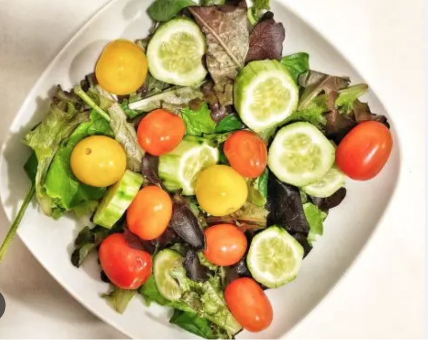 Ensalada de lechuga y tomate de colores con jamón de york.